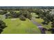 This aerial view shows a well-manicured golf course with mature trees, ponds and lush green grass at 36901 Tara Ave, Zephyrhills, FL 33542