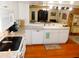 Bright kitchen featuring white cabinets, stainless appliances, granite countertops, and wooden floors at 36901 Tara Ave, Zephyrhills, FL 33542