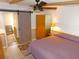 Bedroom featuring ceiling fan, adjacent bathroom and wood-look floors at 36901 Tara Ave, Zephyrhills, FL 33542
