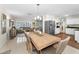 Spacious dining area with a large wooden table, modern lighting, and a view into the living room and kitchen areas at 4191 Maple Ne St, St Petersburg, FL 33703