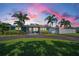 Charming home featuring mature palm trees, a circular driveway, and a well-maintained lawn under a beautiful sunset sky at 4191 Maple Ne St, St Petersburg, FL 33703