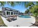 Backyard oasis with a sparkling pool, dining set, and lush tropical foliage at 4710 Travertine Dr, Tampa, FL 33615