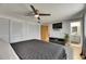 This primary bedroom features a ceiling fan, television, mounted console, and attached bathroom at 4710 Travertine Dr, Tampa, FL 33615