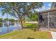 View of the screened lanai and a serene pond with a fountain in a lush backyard setting at 4734 67Th N Ave, Pinellas Park, FL 33781