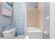 Bathroom with shower and tub combo featuring blue pattern shower curtain, and neutral colored tiles at 4734 67Th N Ave, Pinellas Park, FL 33781