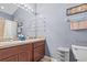 Bathroom featuring double sinks, framed mirror with lighting and beige countertop vanity, accented by gray walls at 4734 67Th N Ave, Pinellas Park, FL 33781