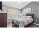 Bedroom with gray walls, wood-look flooring, and large window providing natural light at 4734 67Th N Ave, Pinellas Park, FL 33781