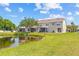 Beautiful exterior view of the back of the townhome overlooking a serene pond and lush green lawn at 4734 67Th N Ave, Pinellas Park, FL 33781