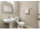 Elegant half bathroom with a pedestal sink, decorative mirror, and neutral color scheme at 5127 6Th N Way, St Petersburg, FL 33703