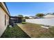 View of the home's exterior, featuring a screened porch, an AC unit, and a spacious green yard at 6118 Becklin Pl, Riverview, FL 33578