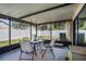 A covered and screened-in lanai with a table and chairs, offering a relaxing outdoor living space at 6118 Becklin Pl, Riverview, FL 33578