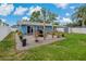 Wide backyard view of a home featuring patio, seating area, stylish landscaping, and a white fence at 6471 109Th N Ter, Pinellas Park, FL 33782