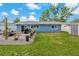 Landscaped backyard of a home with a patio, stylish outdoor seating, and a small shed on green grass at 6471 109Th N Ter, Pinellas Park, FL 33782
