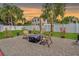 Relaxing backyard patio with chairs, a fire pit, stone ground cover, and manicured green grass at 6471 109Th N Ter, Pinellas Park, FL 33782