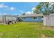 Grassy backyard showcasing a house with outdoor seating and a storage shed on a sunny day at 6471 109Th N Ter, Pinellas Park, FL 33782