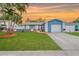 Charming blue single-story home with a well-manicured lawn, palm trees, and a freshly painted garage door at 6471 109Th N Ter, Pinellas Park, FL 33782