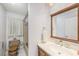 Simple bathroom with a combo shower-tub, single sink vanity, and a framed mirror at 6520 Meadowbrook Ln, New Port Richey, FL 34653