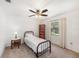 Bright bedroom features neutral carpet, a ceiling fan, and a window overlooking the serene backyard at 6520 Meadowbrook Ln, New Port Richey, FL 34653