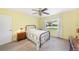 Comfortable bedroom showcases neutral carpet, soft yellow walls, and a sunlit window offering pleasant neighborhood views at 6520 Meadowbrook Ln, New Port Richey, FL 34653