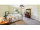 This charming bedroom features a plush carpet, light yellow walls, and an antique dresser with marble accents at 6520 Meadowbrook Ln, New Port Richey, FL 34653