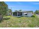 Home exterior with screened-in porch and well-maintained yard at 6520 Meadowbrook Ln, New Port Richey, FL 34653