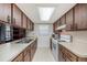 Galley style kitchen with ample counter space, wood cabinets, and a bright skylight at 6520 Meadowbrook Ln, New Port Richey, FL 34653