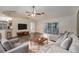 Spacious living room with hardwood floors, a ceiling fan, and access to the patio at 7318 Lamplighter St, Spring Hill, FL 34606