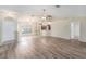 Open-concept living area features wood floors, natural light, and access to other rooms at 7318 Lamplighter St, Spring Hill, FL 34606