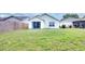 Cozy home featuring a spacious backyard with lush green grass and a sliding door to access the house at 7855 Bristol Park Dr., Apollo Beach, FL 33572