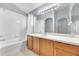 Bathroom featuring a shower-tub combo, white tile, and a large mirror at 7855 Bristol Park Dr., Apollo Beach, FL 33572