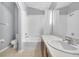 Bathroom featuring a shower-tub combo, white tile, and a large mirror and white countertop at 7855 Bristol Park Dr., Apollo Beach, FL 33572