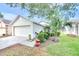 Single-story home with a two-car garage, lush landscaping, and a healthy lawn at 7855 Bristol Park Dr., Apollo Beach, FL 33572