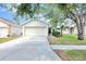 Inviting single-story home with a two-car garage, manicured lawn, and mature palm trees at 7855 Bristol Park Dr., Apollo Beach, FL 33572