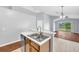 Kitchen island featuring a stainless steel sink, white countertops, and wood cabinets at 7855 Bristol Park Dr., Apollo Beach, FL 33572
