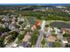 Aerial view of a single-story home with tile roof, two car garage, fountain, and lake view in a wooded, desirable neighborhood at 800 Belted Kingfisher S Dr, Palm Harbor, FL 34683