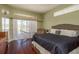 Bedroom featuring a large bed, hardwood floors, neutral tones, and sliding doors to the outdoor pool area at 800 Belted Kingfisher S Dr, Palm Harbor, FL 34683