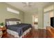 Bedroom featuring a king-sized bed, hardwood floors, neutral tones, and access to an en-suite bathroom at 800 Belted Kingfisher S Dr, Palm Harbor, FL 34683