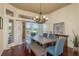 Charming dining room features hardwood floors, views to the backyard, modern chandelier and rustic dining table at 800 Belted Kingfisher S Dr, Palm Harbor, FL 34683
