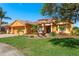 Stunning single Gathering home features a meticulously landscaped front yard, terracotta roof, and charming water fountain feature at 800 Belted Kingfisher S Dr, Palm Harbor, FL 34683