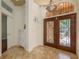 Elegant foyer features a decorative front door with iron detailing and tiled floors, exuding sophisticated charm at 800 Belted Kingfisher S Dr, Palm Harbor, FL 34683