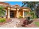 Inviting entrance featuring stone walkway, water feature and decorative glass front doors and stately white pillars at 800 Belted Kingfisher S Dr, Palm Harbor, FL 34683
