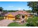 Charming single-story home featuring a tile roof, two car garage, paver driveway, and a beautifully landscaped front yard with fountain at 800 Belted Kingfisher S Dr, Palm Harbor, FL 34683