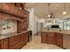 Kitchen featuring dark wood cabinets, wine fridge, light countertops, tile backsplash, and pendant lighting at 800 Belted Kingfisher S Dr, Palm Harbor, FL 34683