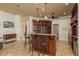 Kitchen with an island featuring bar stool seating, dark wood cabinets, granite countertops, and stainless appliances at 800 Belted Kingfisher S Dr, Palm Harbor, FL 34683