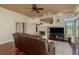 Bright living room featuring a fireplace, large-screen TV, hardwood floors, and sliding door access to the outdoors at 800 Belted Kingfisher S Dr, Palm Harbor, FL 34683