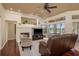 Cozy living room featuring hardwood floors, a fireplace, TV, large window and access to a covered outdoor patio at 800 Belted Kingfisher S Dr, Palm Harbor, FL 34683