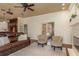 Living room featuring a brown leather sofa, area rug, two armchairs, and view of the bedroom through doorway at 800 Belted Kingfisher S Dr, Palm Harbor, FL 34683