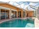 Inviting pool and spa on a screened-in lanai with brick pavers and access to the home's interior at 800 Belted Kingfisher S Dr, Palm Harbor, FL 34683