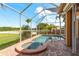 The pool and spa on brick pavers has a screened-in lanai with views of the lake at 800 Belted Kingfisher S Dr, Palm Harbor, FL 34683