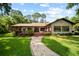 Beautiful backyard featuring a spacious deck, lush lawn, and a stone path at 8011 N Mobley Rd, Odessa, FL 33556